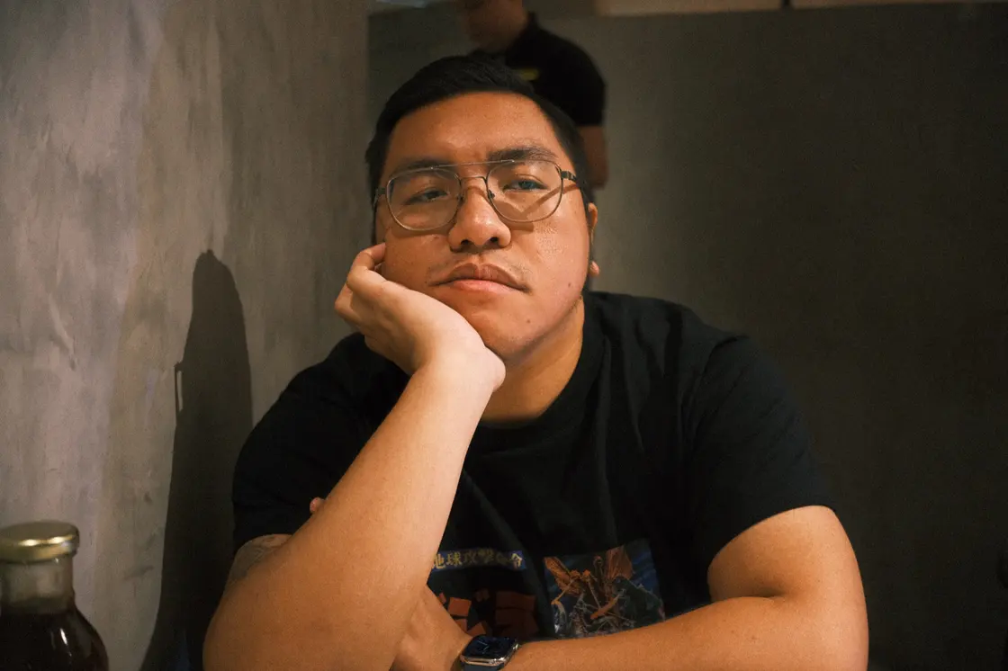 Archieval Mariano seated at a table, resting his face on one hand