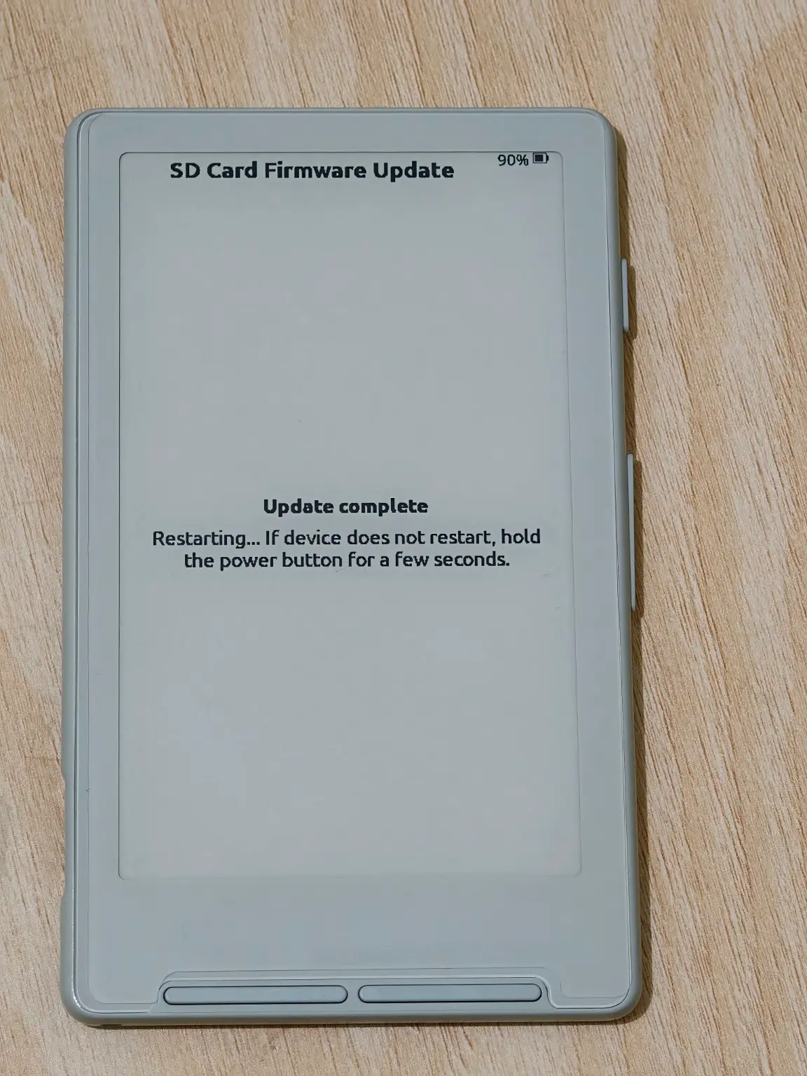 The XTEINK X4 showing Update complete and a restarting message.