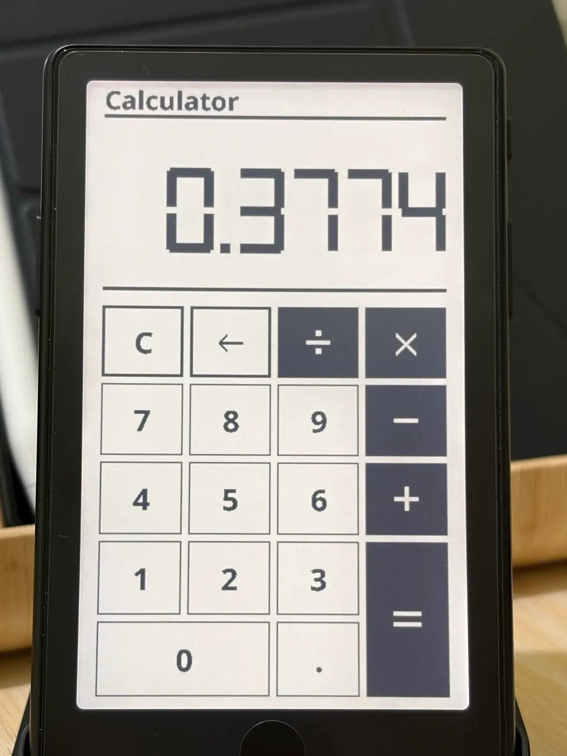 Calculator on an XTEINK X4 Pro showing 0.3774 above a keypad of digits and operators.
